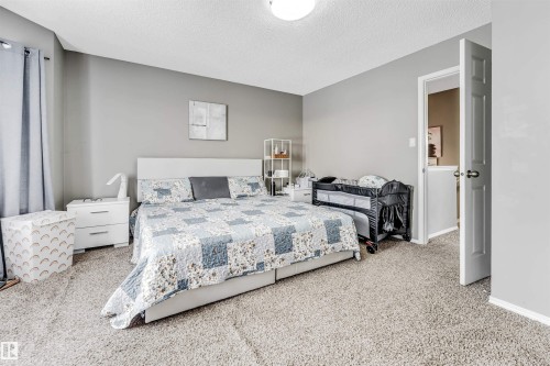 Carpeted bedroom with a textured ceiling and baseboards - 4404 150 Avenue, Edmonton, AB - Indoor Photo Showing Bedroom