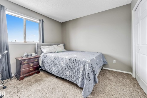 Bedroom featuring a closet, light colored carpet, and a textured ceiling - 4404 150 Avenue, Edmonton, AB - Indoor Photo Showing Bedroom