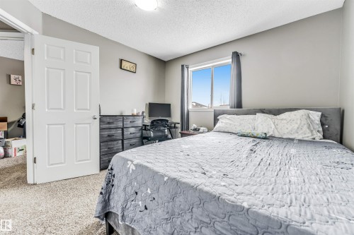 Bedroom featuring a textured ceiling and light carpet - 4404 150 Avenue, Edmonton, AB - Indoor Photo Showing Bedroom