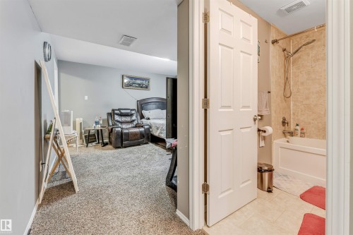 Corridor featuring light carpet and baseboards - 4404 150 Avenue, Edmonton, AB - Indoor