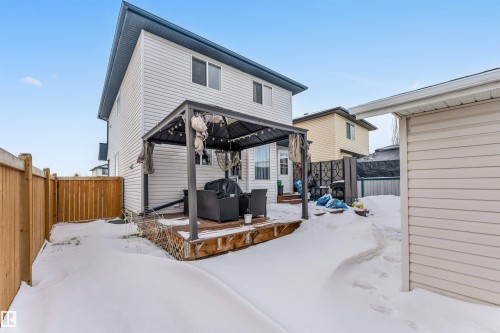 Snow covered house featuring a fenced backyard, a gazebo, a wooden deck, and outdoor furniture - 4404 150 Avenue, Edmonton, AB - Outdoor With Exterior