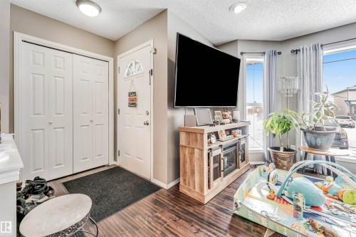 Living area featuring a textured ceiling and dark wood-type flooring - 4404 150 Avenue, Edmonton, AB - Indoor