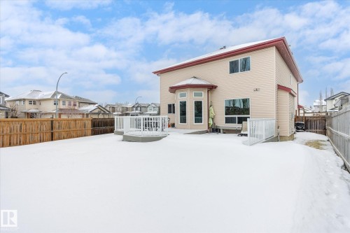 Snow covered house featuring a residential view, a wooden deck, and a fenced backyard - 66 Nadine Way, St. Albert, AB - Outdoor