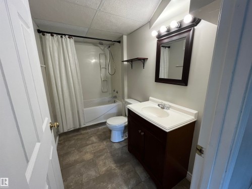 Full bath featuring a paneled ceiling, vanity, shower / bath combo, and stone finish flooring - 130 1 Street, Blue Ridge, AB - Indoor Photo Showing Bathroom