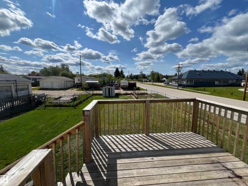 Wooden terrace featuring a residential view, a lawn, and a storage unit - 130 1 Street, Blue Ridge, AB - Outdoor With Deck Patio Veranda