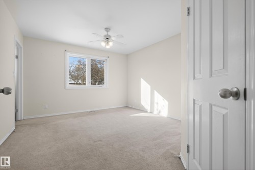 Unfurnished room featuring light colored carpet and ceiling fan - 11435 37A Avenue, Edmonton, AB - Indoor Photo Showing Other Room