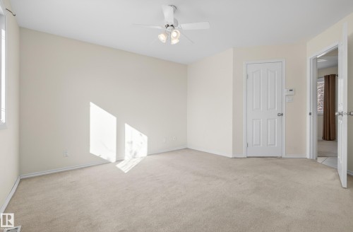 Empty room with a ceiling fan and light colored carpet - 11435 37A Avenue, Edmonton, AB - Indoor Photo Showing Other Room