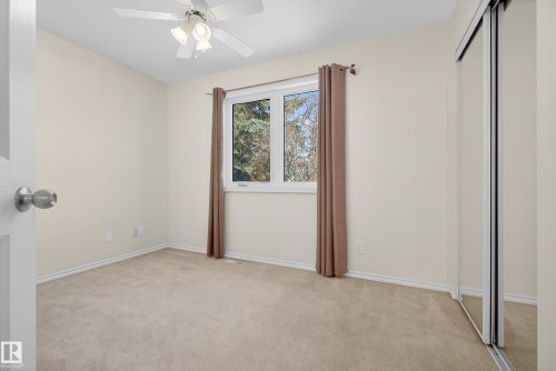 Unfurnished bedroom featuring a closet, light colored carpet, and ceiling fan - 11435 37A Avenue, Edmonton, AB - Indoor Photo Showing Other Room