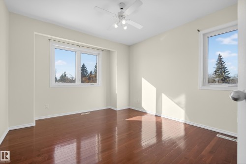 Empty room with dark wood-style floors, a ceiling fan, and plenty of natural light - 11435 37A Avenue, Edmonton, AB - Indoor Photo Showing Other Room