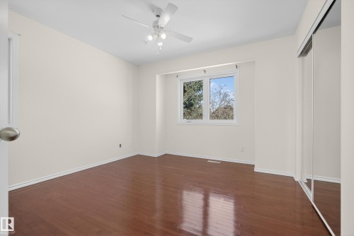 Unfurnished bedroom featuring dark wood finished floors, a closet, and a ceiling fan - 11435 37A Avenue, Edmonton, AB - Indoor Photo Showing Other Room