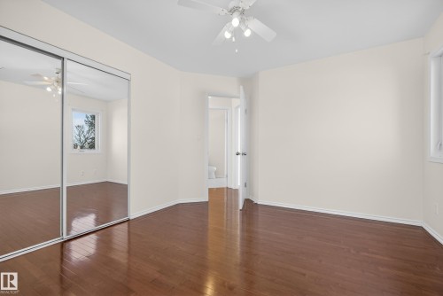 Unfurnished bedroom featuring ceiling fan, dark wood finished floors, and a closet - 11435 37A Avenue, Edmonton, AB - Indoor Photo Showing Other Room