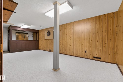 Finished basement featuring carpet flooring, a textured ceiling, and wood walls - 11435 37A Avenue, Edmonton, AB - Indoor Photo Showing Other Room