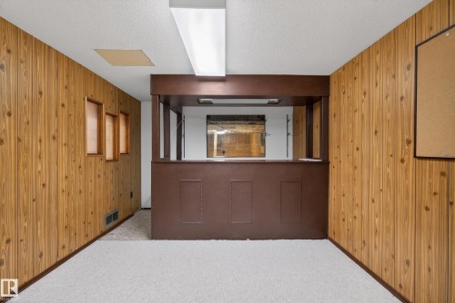 Hall with wood walls, a textured ceiling, and carpet floors - 11435 37A Avenue, Edmonton, AB - Indoor Photo Showing Other Room