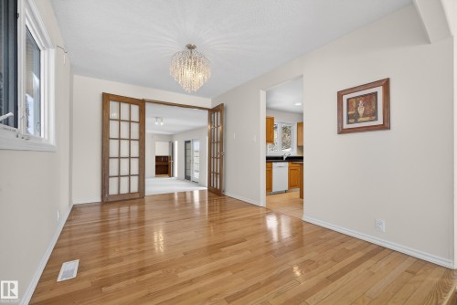 Unfurnished dining area featuring light wood-style floors, a chandelier, and french doors - 11435 37A Avenue, Edmonton, AB - Indoor Photo Showing Other Room