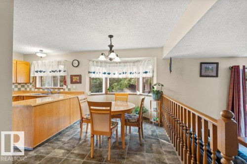 Dining space with a textured ceiling and a chandelier - 10429 28A Avenue, Edmonton, AB - Indoor Photo Showing Dining Room