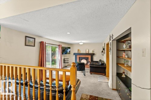 Office space with a textured ceiling, light carpet, and a fireplace - 10429 28A Avenue, Edmonton, AB - Indoor Photo Showing Other Room