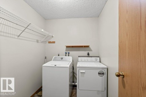Laundry room with washing machine and clothes dryer and a textured ceiling - 10429 28A Avenue, Edmonton, AB - Indoor Photo Showing Laundry Room