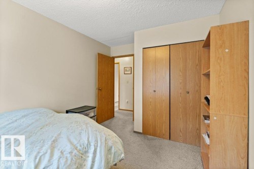 Bedroom with light carpet, a closet, and a textured ceiling - 10429 28A Avenue, Edmonton, AB - Indoor Photo Showing Bedroom