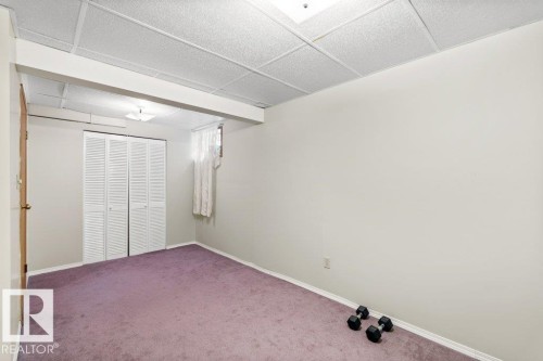 Unfurnished bedroom featuring carpet floors, a drop ceiling, and a closet - 10429 28A Avenue, Edmonton, AB - Indoor Photo Showing Other Room
