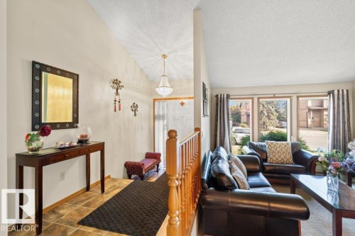 Tiled living area featuring lofted ceiling, a textured ceiling, and a chandelier - 10429 28A Avenue, Edmonton, AB - Indoor Photo Showing Living Room