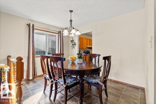 Dining area with a textured ceiling and a chandelier - 10429 28A Avenue, Edmonton, AB - Indoor Photo Showing Dining Room