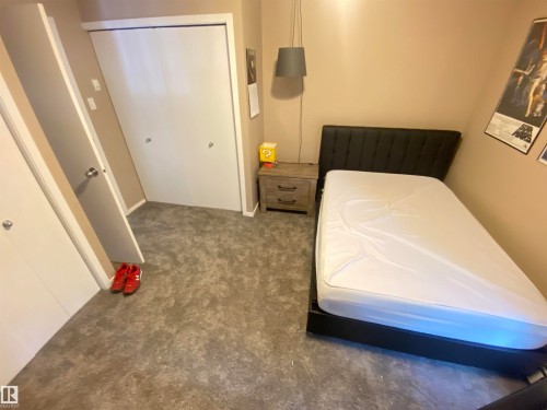 Bedroom with dark colored carpet and a closet - 11176 83 Avenue, Edmonton, AB - Indoor Photo Showing Bedroom