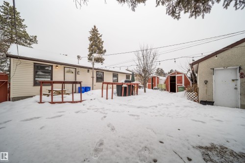 Snow covered house featuring a storage shed and a deck - 8908 130 Avenue Nw, Edmonton, AB - Outdoor With Exterior