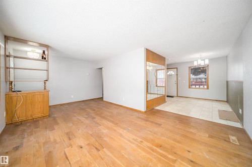 Unfurnished living room with light wood-style flooring and baseboards - 8908 130 Avenue Nw, Edmonton, AB - Indoor Photo Showing Other Room