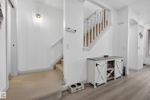 Staircase featuring a textured ceiling and wood finished floors - 44 903 Rutherford Road, Edmonton, AB - Indoor Photo Showing Other Room