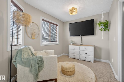 Living area featuring light colored carpet and a textured ceiling - 44 903 Rutherford Road, Edmonton, AB - Indoor
