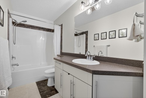 Bathroom featuring vanity, a textured ceiling, and shower / tub combo - 44 903 Rutherford Road, Edmonton, AB - Indoor Photo Showing Bathroom