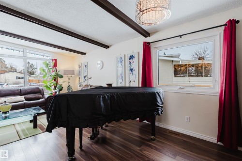 Sitting room with beamed ceiling, wood finished floors, and a textured ceiling - 11519 37A Avenue, Edmonton, AB - Indoor Photo Showing Other Room
