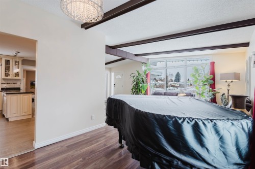 Game room featuring a textured ceiling, light wood-style floors, and beam ceiling - 11519 37A Avenue, Edmonton, AB - Indoor
