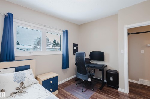 Bedroom with dark wood-style flooring and an office area - 11519 37A Avenue, Edmonton, AB - Indoor Photo Showing Bedroom
