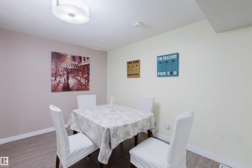 Dining room featuring a textured ceiling and wood finished floors - 11519 37A Avenue, Edmonton, AB - Indoor Photo Showing Dining Room