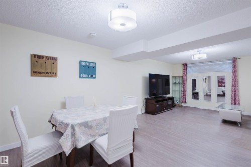 Dining space featuring wood finished floors and a textured ceiling - 11519 37A Avenue, Edmonton, AB - Indoor Photo Showing Dining Room