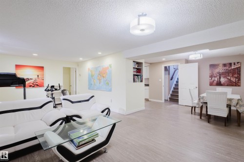 Living area featuring light wood-style flooring, a textured ceiling, and recessed lighting - 11519 37A Avenue, Edmonton, AB - Indoor
