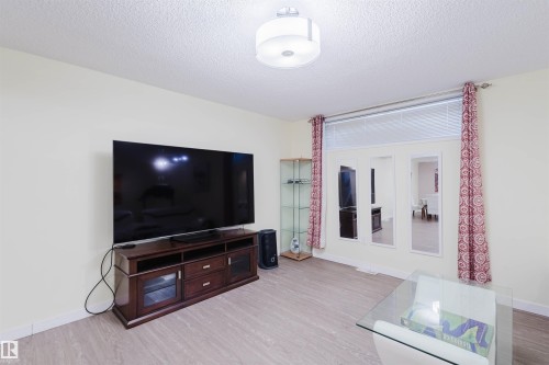 Living room with light wood-style floors and a textured ceiling - 11519 37A Avenue, Edmonton, AB - Indoor