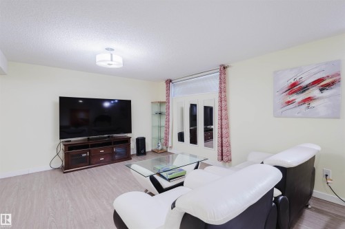Living room with wood finished floors and a textured ceiling - 11519 37A Avenue, Edmonton, AB - Indoor Photo Showing Living Room