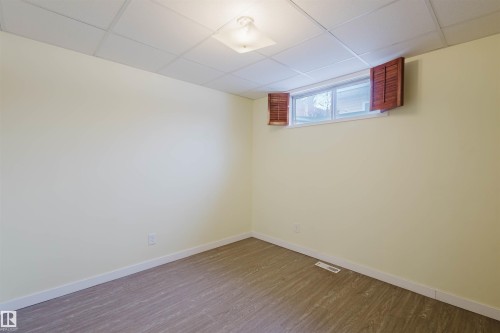 Basement featuring a drop ceiling and dark wood finished floors - 11519 37A Avenue, Edmonton, AB - Indoor Photo Showing Other Room