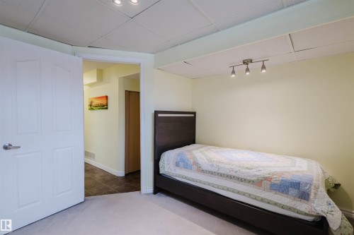 Carpeted bedroom featuring a paneled ceiling and tile patterned floors - 11519 37A Avenue, Edmonton, AB - Indoor Photo Showing Bedroom