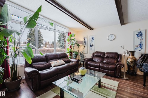 Living area featuring a textured ceiling, dark wood finished floors, and beam ceiling - 11519 37A Avenue, Edmonton, AB - Indoor Photo Showing Living Room