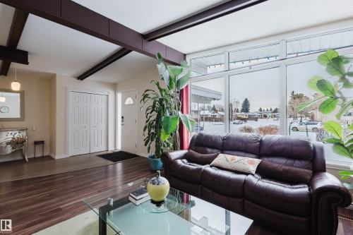 Living room with wood finished floors and lofted ceiling with beams - 11519 37A Avenue, Edmonton, AB - Indoor Photo Showing Living Room