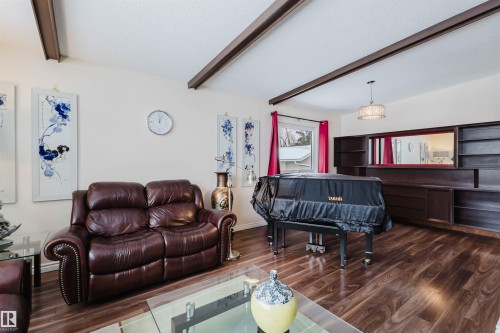 Living area featuring beam ceiling, a textured ceiling, and dark wood-type flooring - 11519 37A Avenue, Edmonton, AB - Indoor