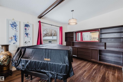 Recreation room featuring dark wood-type flooring, a textured ceiling, and beam ceiling - 11519 37A Avenue, Edmonton, AB - Indoor Photo Showing Bedroom