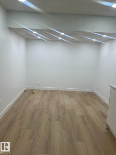 The property features light wood flooring and white walls, complemented by recessed lighting in the ceiling - 9194 Pear Drive Sw, Edmonton, AB - Indoor
