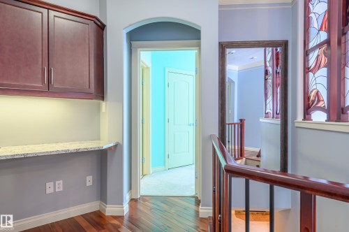 Hall featuring dark wood-type flooring, an upstairs landing, arched walkways, and ornamental molding - 48 Fairway Point(E), Spruce Grove, AB - Indoor Photo Showing Other Room