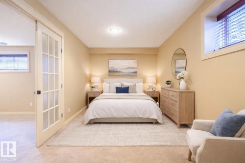 Bedroom with light colored carpet and baseboards this is staged - 48 Fairway Point(E), Spruce Grove, AB - Indoor Photo Showing Bedroom