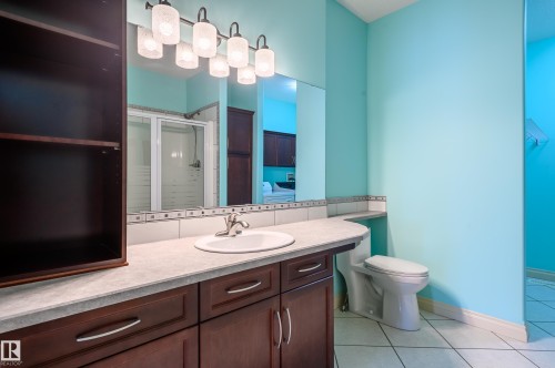 Bathroom with vanity, a shower stall, light tile patterned floors, and decorative backsplash - 48 Fairway Point(E), Spruce Grove, AB - Indoor Photo Showing Bathroom
