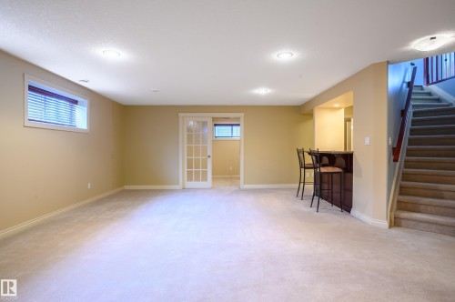 Below grade area with light carpet and bar area - 48 Fairway Point(E), Spruce Grove, AB - Indoor